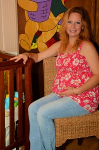 pregnant sitting at crib